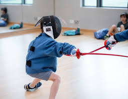 Young child in fencing mask learning the basics